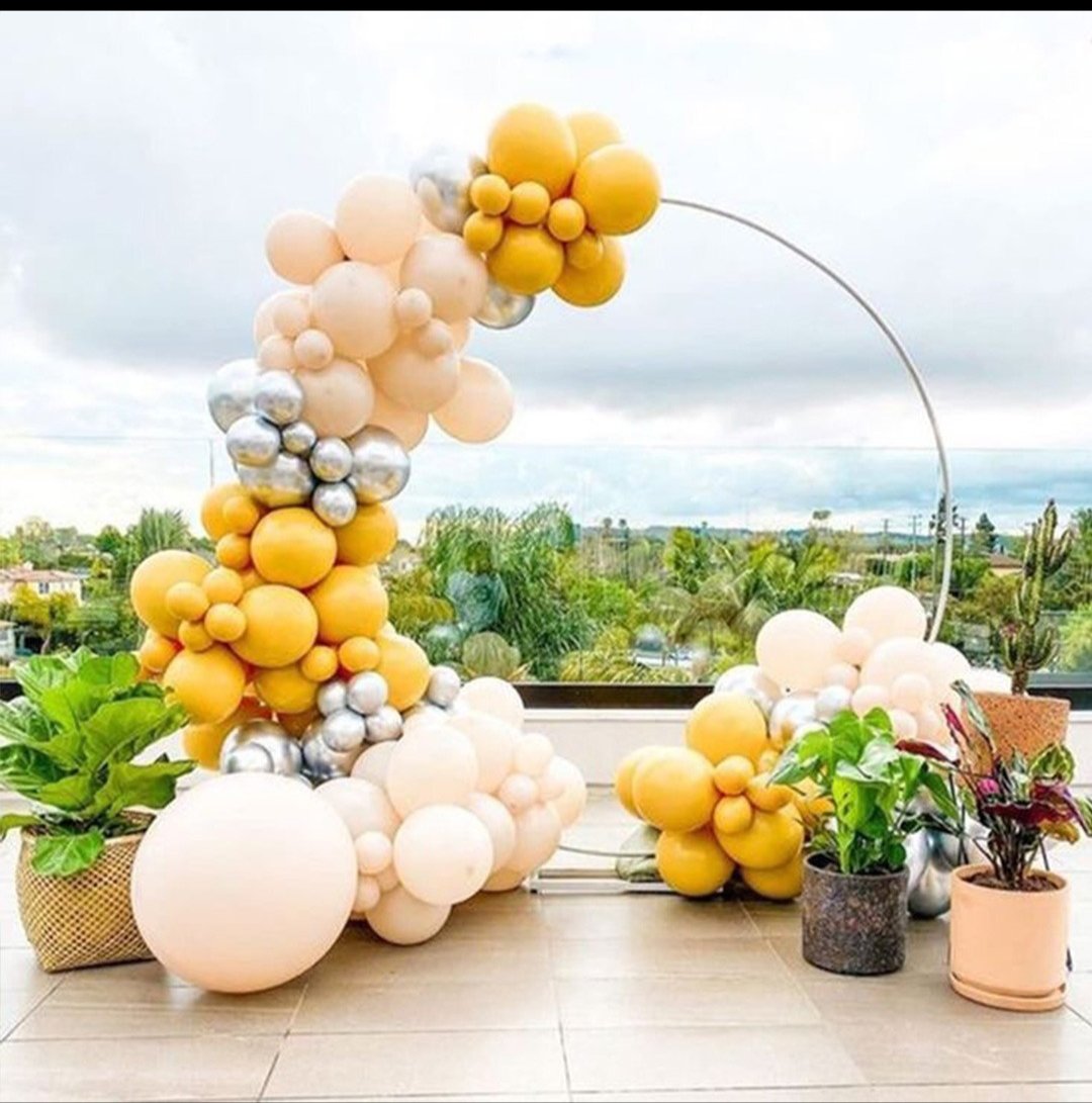 Mustard and blush balloon installation on a terrace